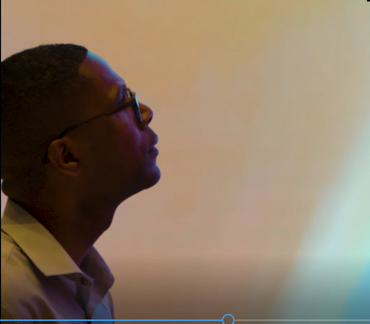 A close up of a man next to the videowall.