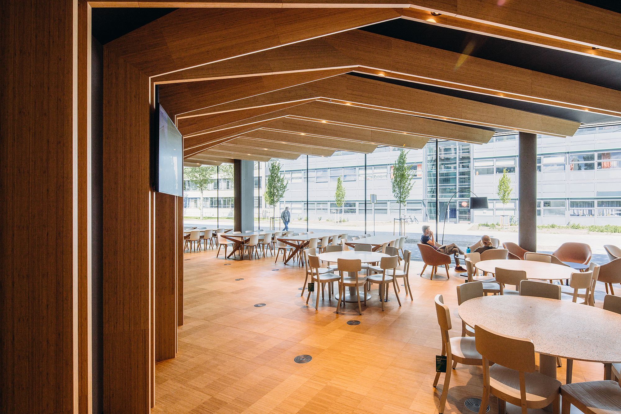 Large room with glass walls, round tables, and chairs.