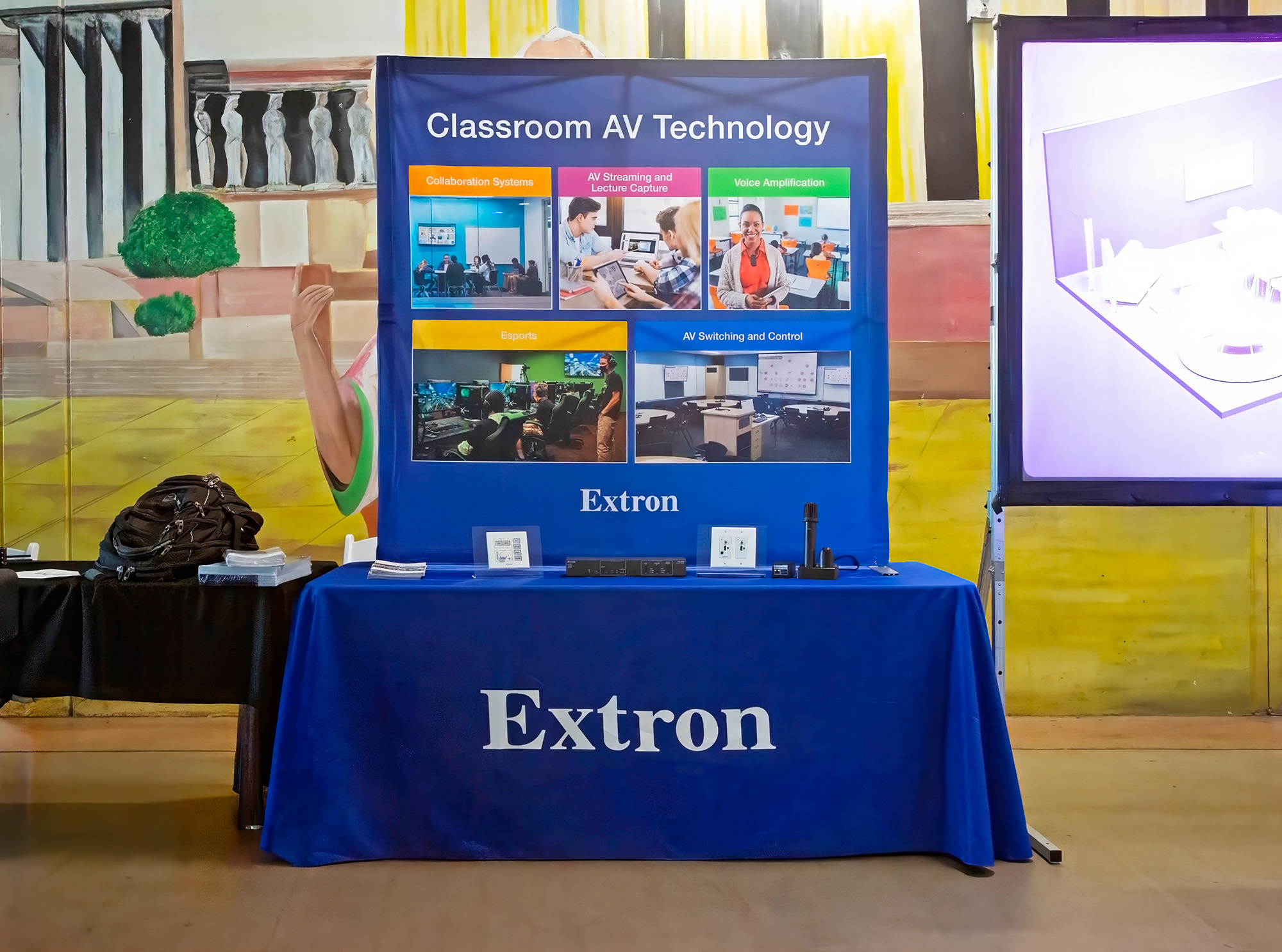 A booth at the Davis Middle School Tournament and Showcase provides visitors with an overview of the Extron technology that supports a CUSD esports lab.