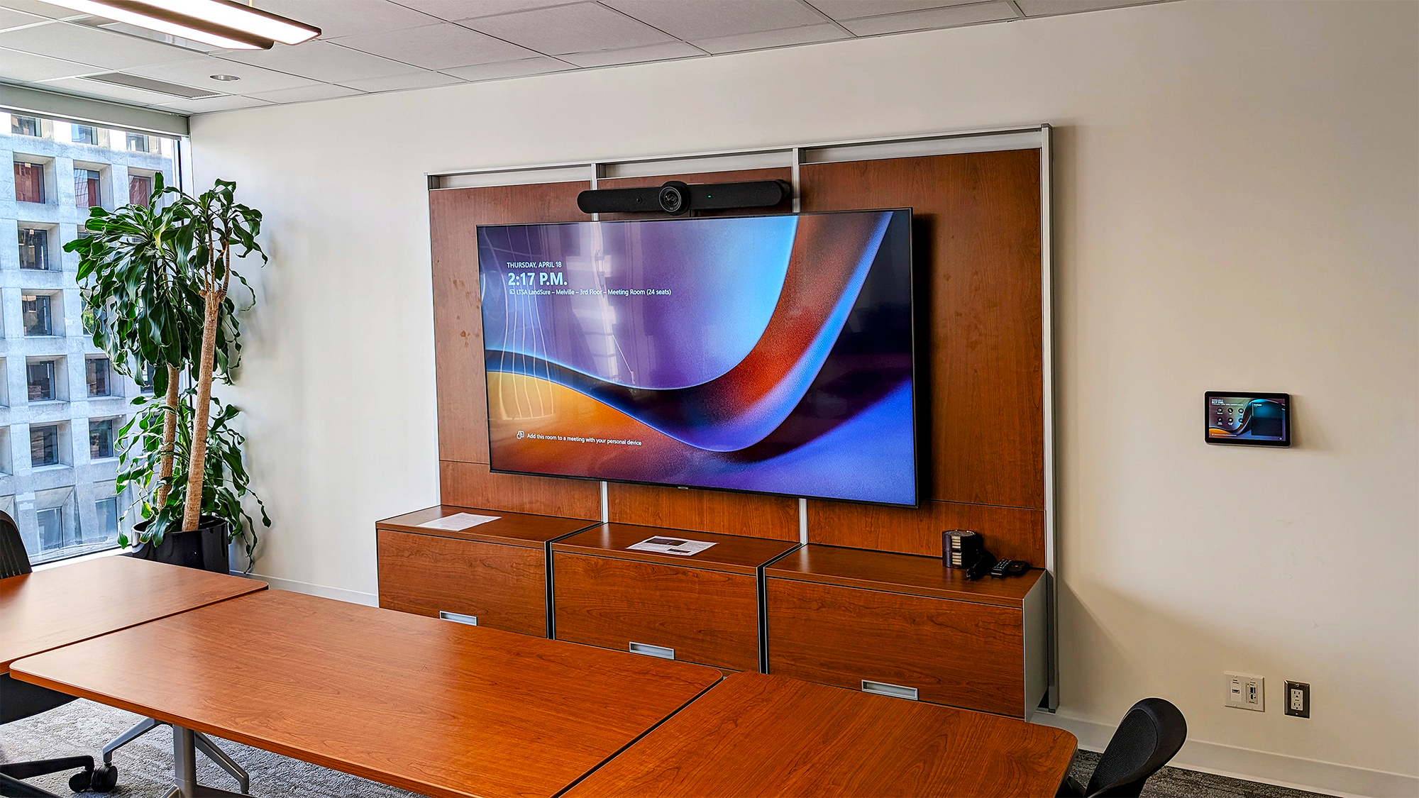 Mounted near the large central display, the Logitech Tap Touch Controller is seamlessly integrated with Extron automation, offering intuitive control over the room's AV system. 