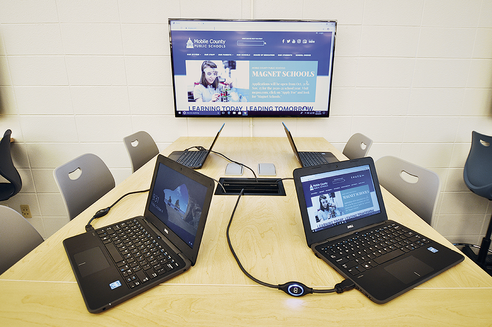 Desk with laptop computers connected by the TeamWork Show Me cable