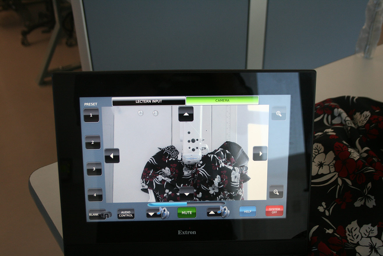 A videoconferencing system display placed on top of a desk