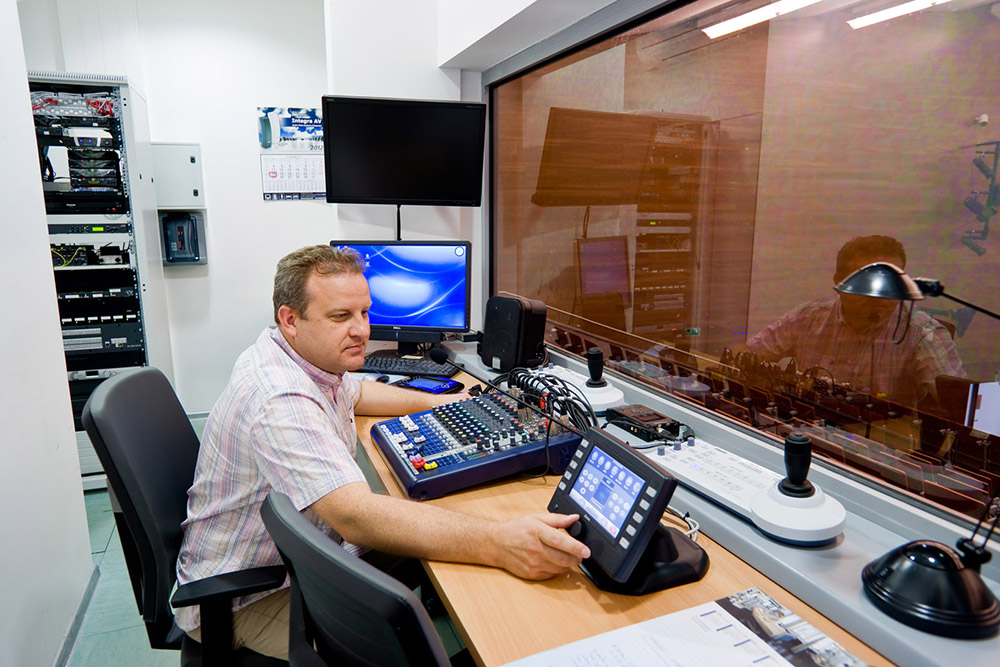 An Extron TouchLink touchpanel helps simplify remote AV system operation from the auditorium’s control room.