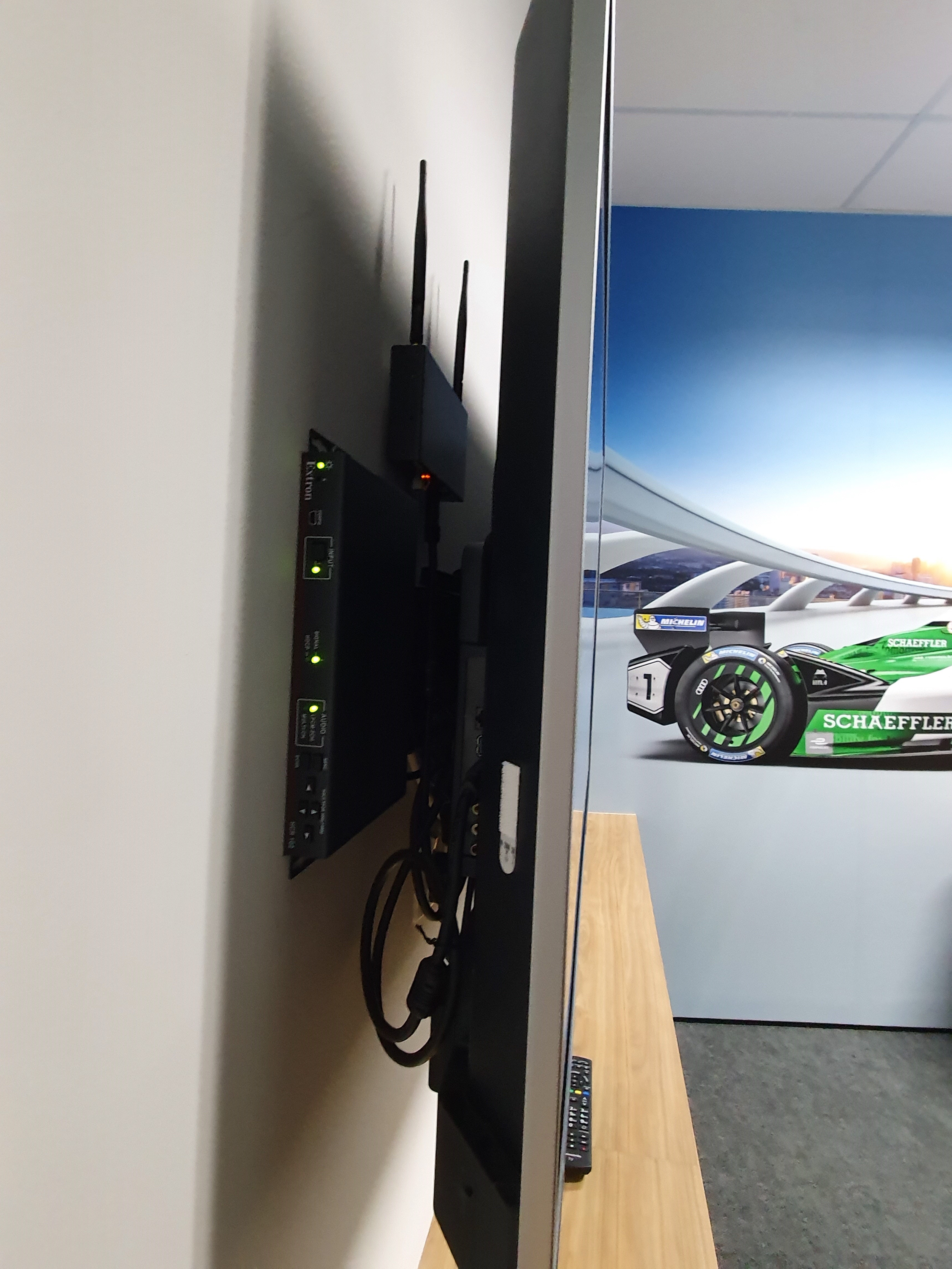 To achieve a sleek and modern environment in board rooms, auditoriums, and think tanks, the low-profile Extron HC 404 collaboration receiver and ShareLink wireless gateway are installed behind the flat panel display.