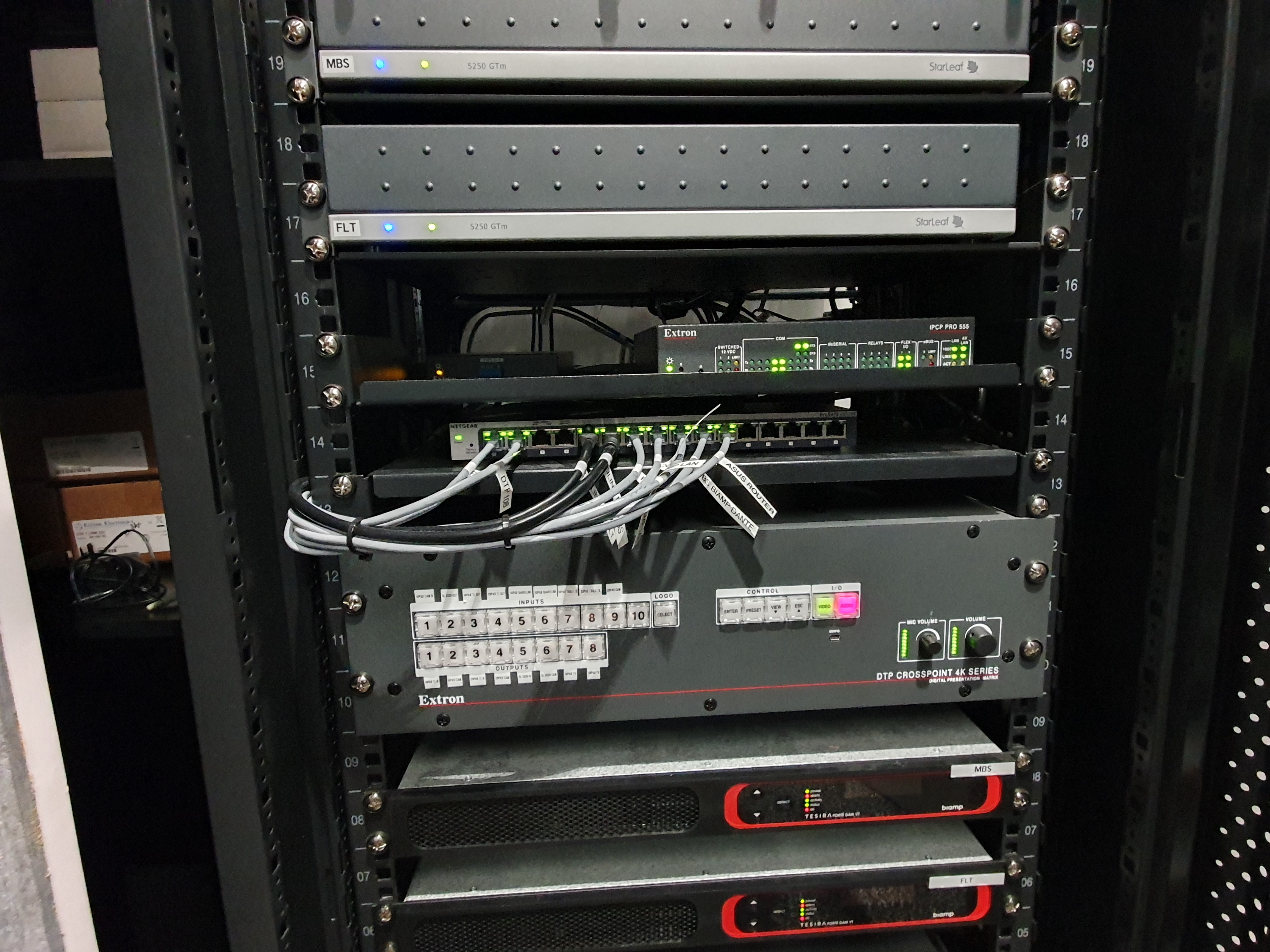 A DTP CrossPoint 108 4K scaling presentation matrix switcher rack-mounted in a back corner of the 20-seat conference room provides AV and control signal routing within both it and the 14-seat conference room.