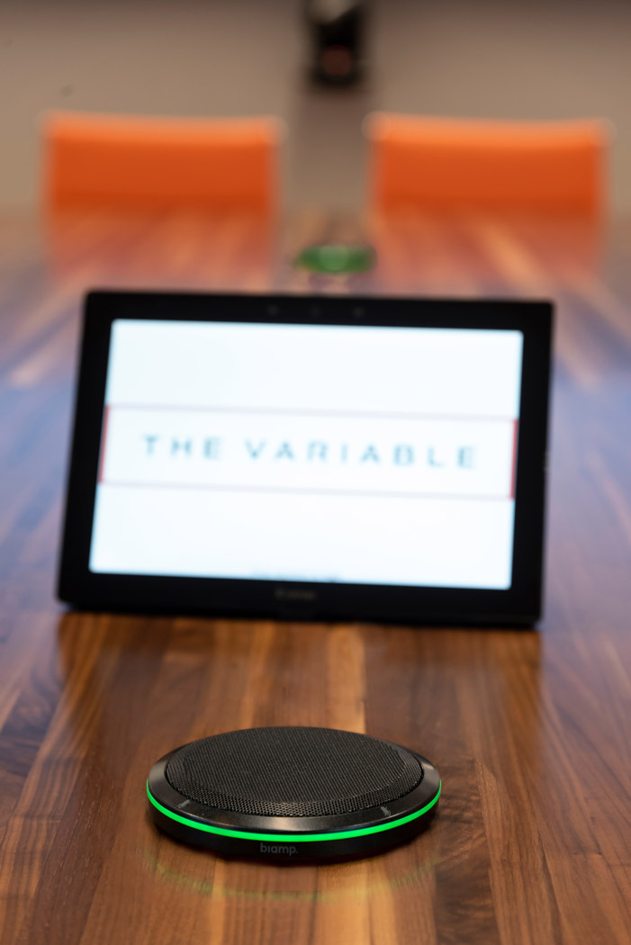 A closeup image of a touchpanel placed on a conference room desk.