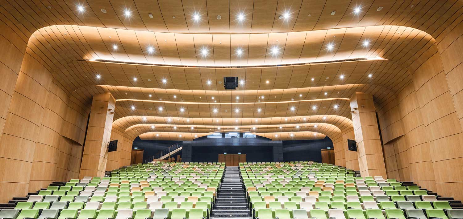 Auditorium has ceiling-mounted projector for the on-stage screen plus 55” flat panel displays in the audience seating area.