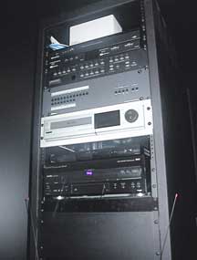 The Extron CrossPoint 124 is mounted in the rack behind the rear projection screen