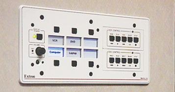 The Extron MLC 206 MediaLink Controller is mounted near the door of the conference room and includes the Extron IRCM-VCR and IRCM-DVD control modules.